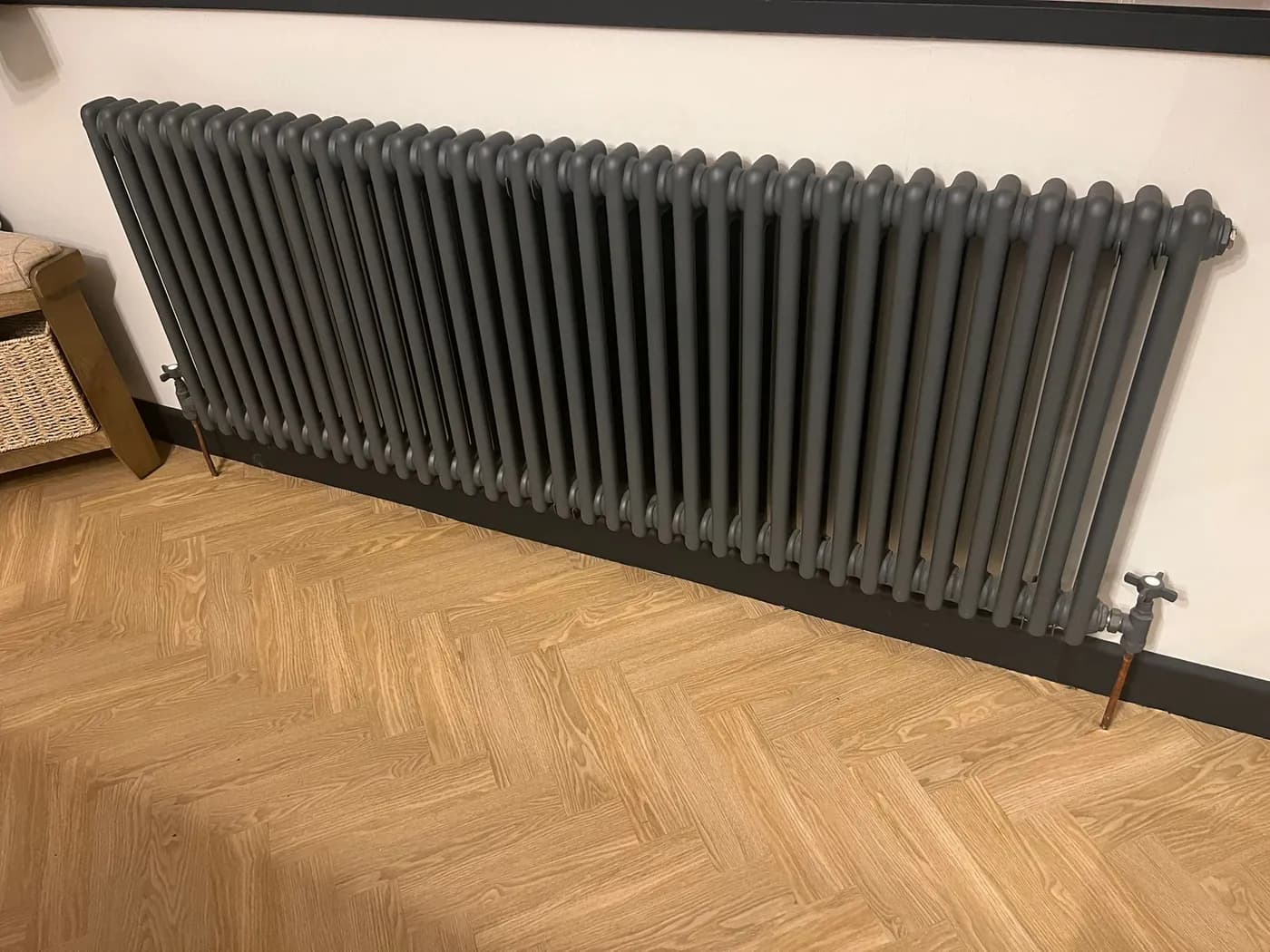 Anthracite column radiator installation with herringbone flooring in Bridgend