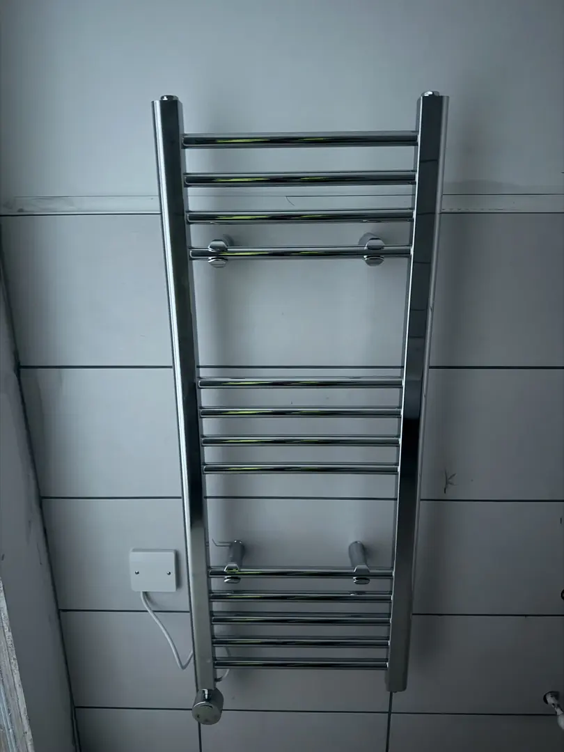 Heated towel rail installation in a bathroom by plumber in Pyle