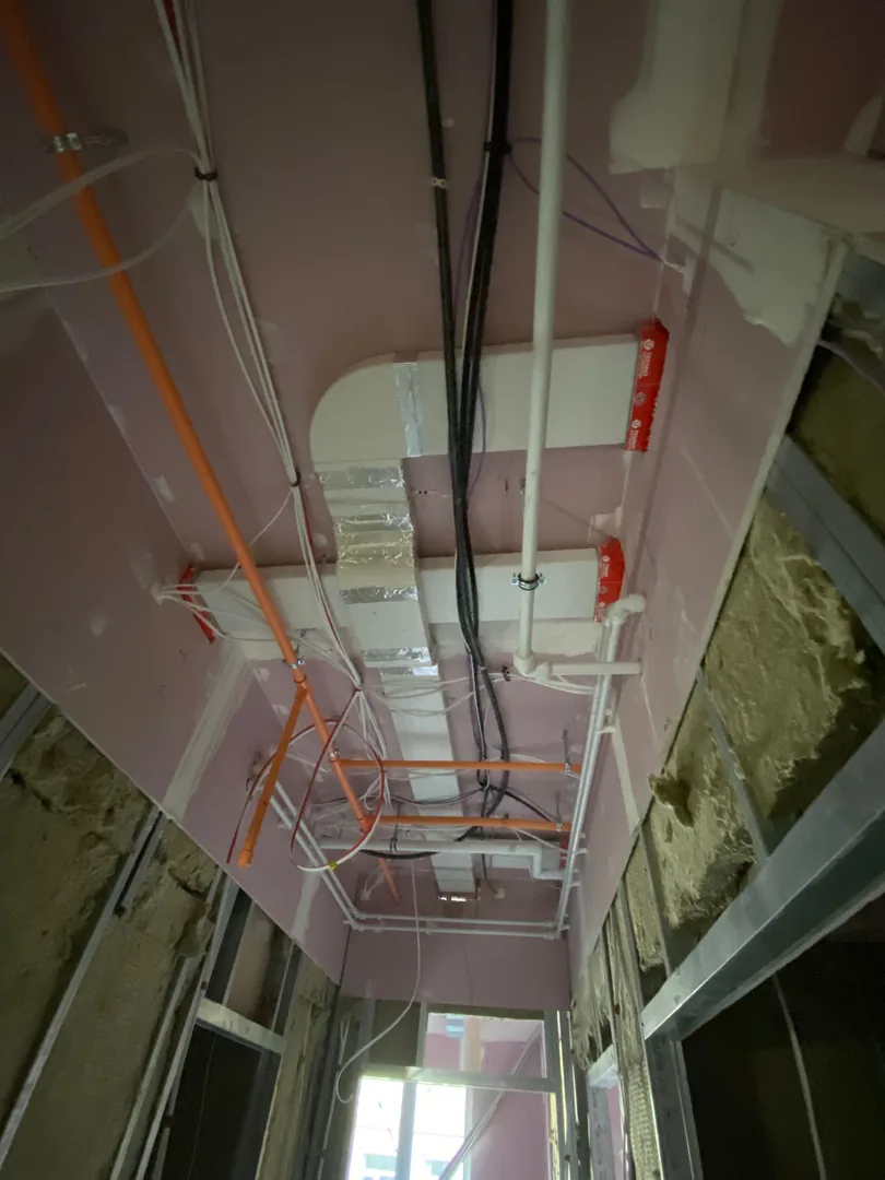 MVHR ducting first fix alongside heating pipework in a Bridgend ceiling void
