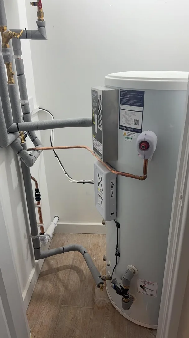 MVHR ductwork installed alongside hot water cylinder in a Bridgend property