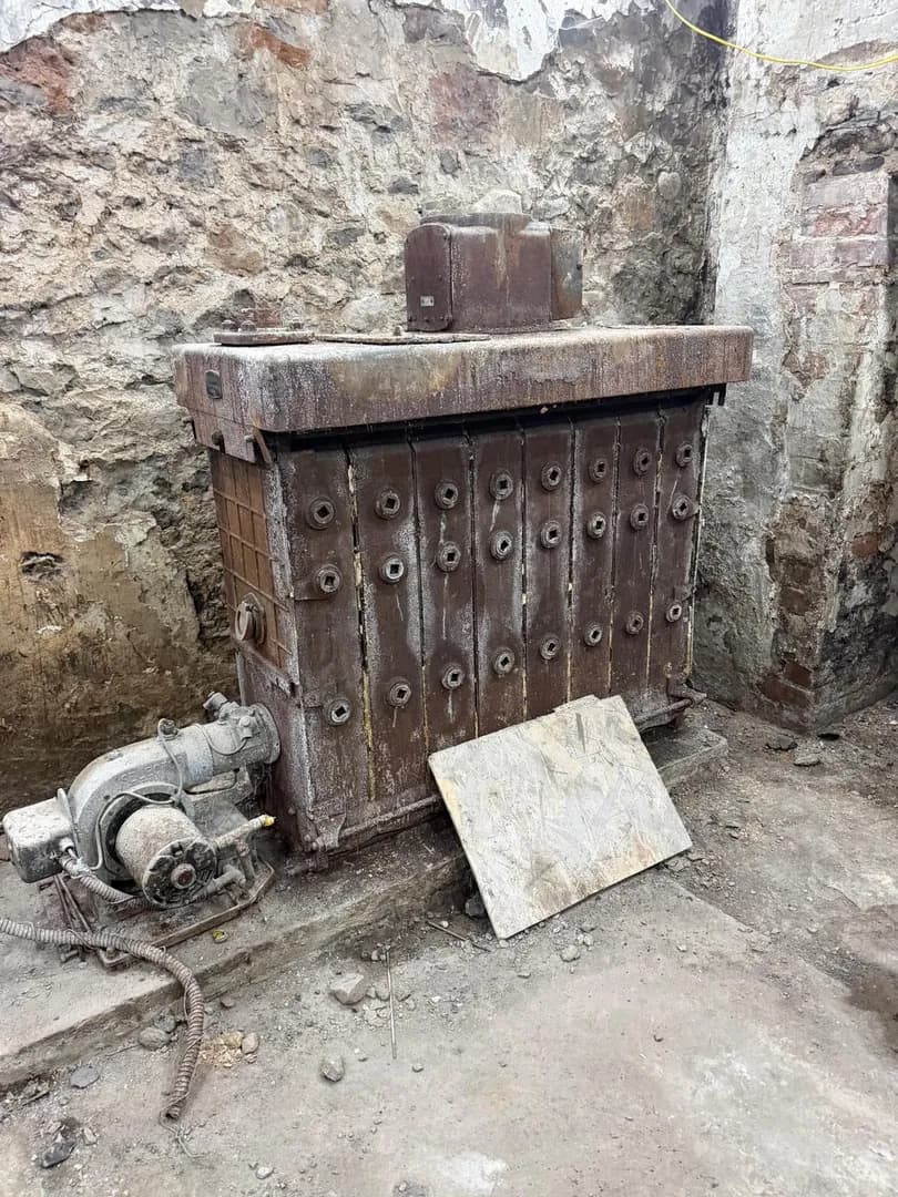 Old cast iron boiler removal during MVHR retrofit upgrade in Bridgend