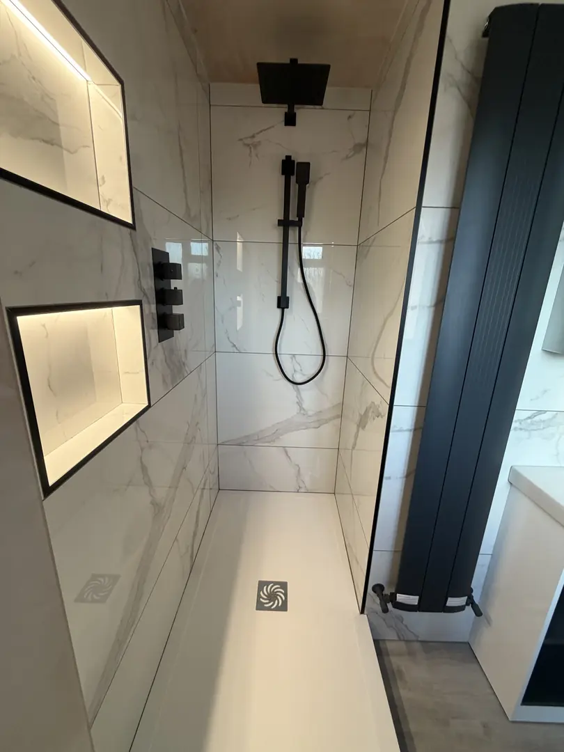 Luxury walk-in shower installation with marble tiles and black fixtures in Port Talbot