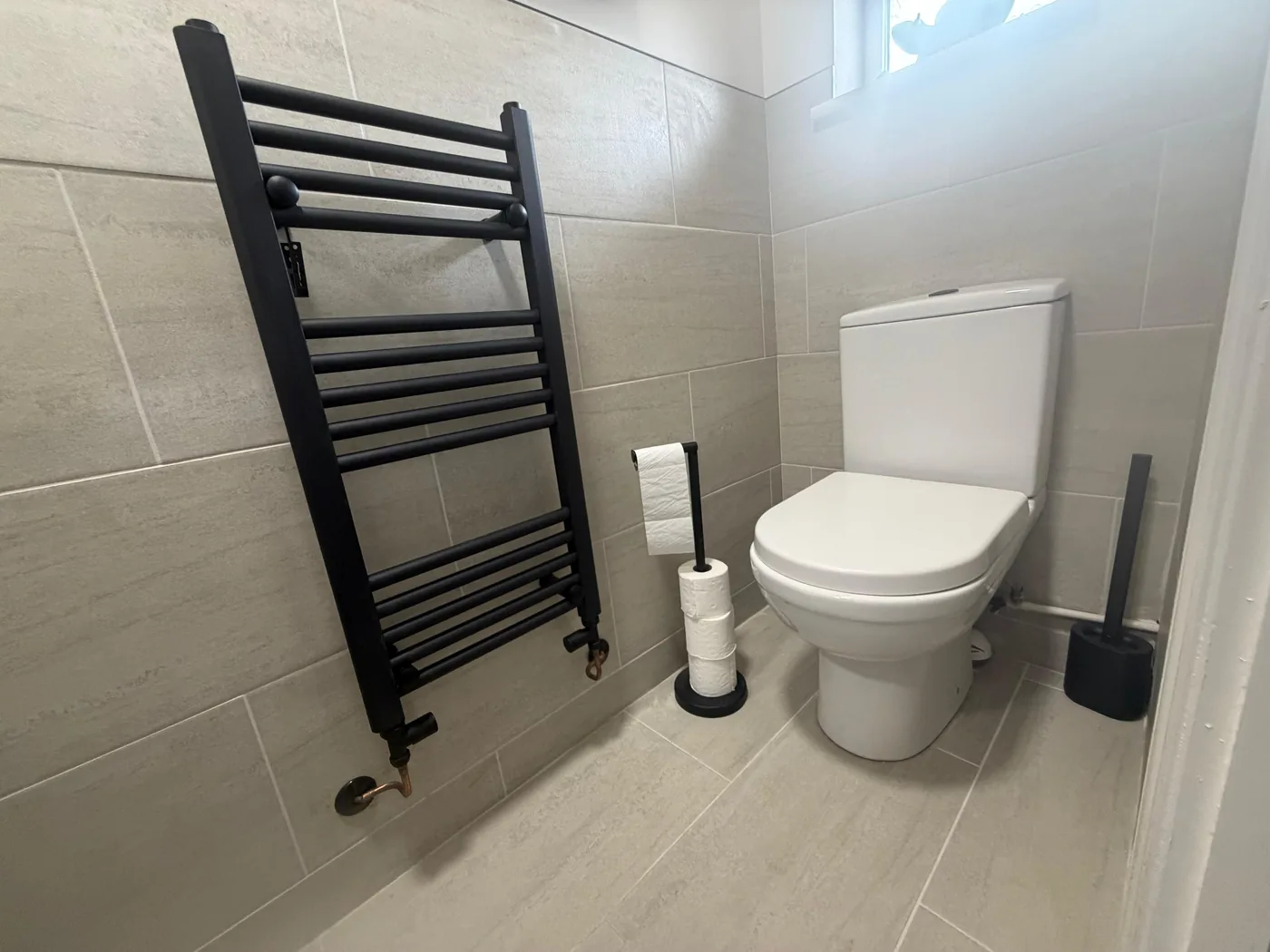 Black heated towel rail close-up in a bathroom installation in Cardiff