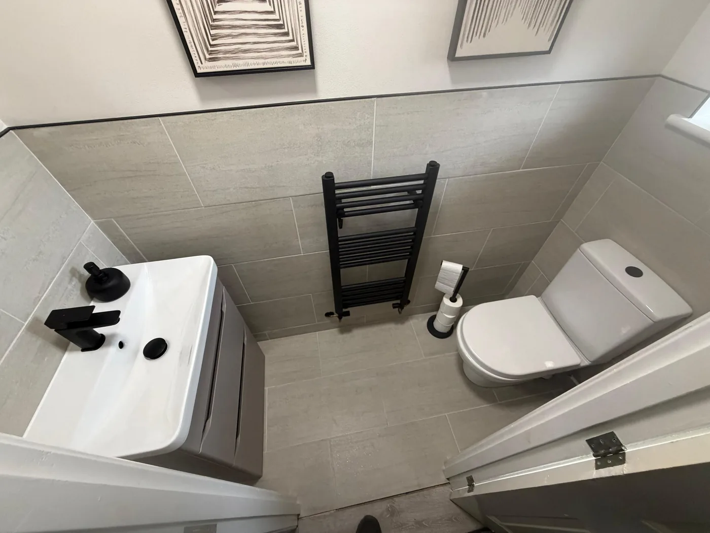 Modern bathroom installation with grey tiles and black fixtures in Bridgend
